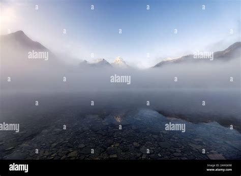 Mount Assiniboine In Blue Foggy Reflection On Lake Magog At Provincial