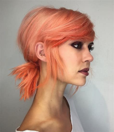 Low Messy Textured Ponytail With Side Swept Bangs And Pink Coral Hair