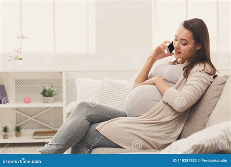 Mujer Embarazada Sonriente Que Habla En Su Smartphone Foto De Archivo Imagen De Concepto