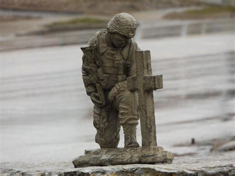 Soldier Kneeling At Memorial