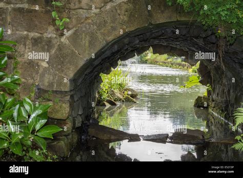 A Stone Bridge Over A Stream Leading Into A Lake Stock Photo Alamy