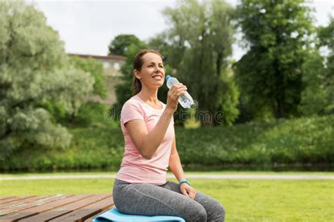 Woman Drinking Water After Exercising In Park Stock Photo Image Of