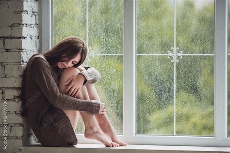 Beautiful Young Woman Sitting Alone Close To Window With Rain Drops Sexy And Sad Girl Concept
