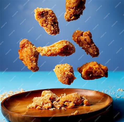 Premium AI Image | Flying chicken pieces in breadcrumbs with wooden