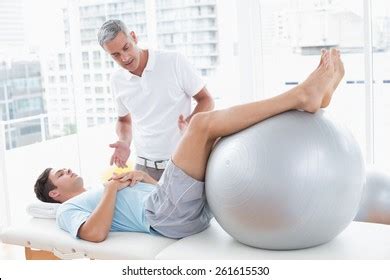 Therapist Helping His Patient Exercise Ball Stock Photo 261615530