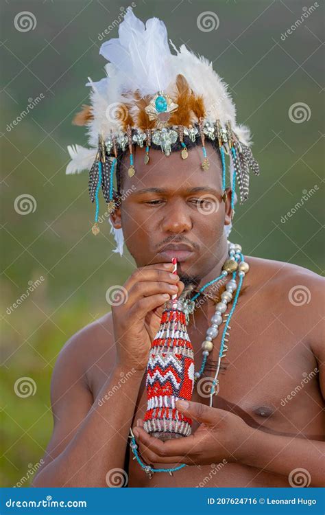 A Traditional African Dressed Male With A Beaded Headdress Drink From A Beaded Bottle Stock