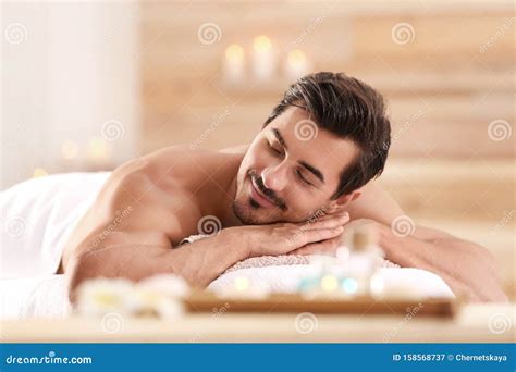 Handsome Young Man Relaxing On Massage Table In Salon Stock Image