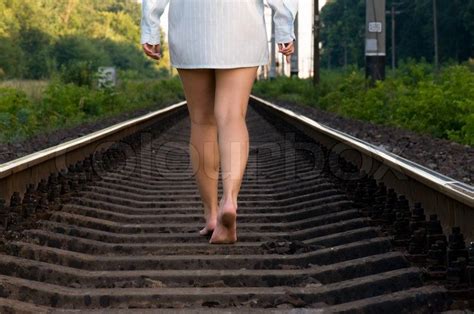 Young Beautiful Woman Walking On A Railroad Track Stock Photo