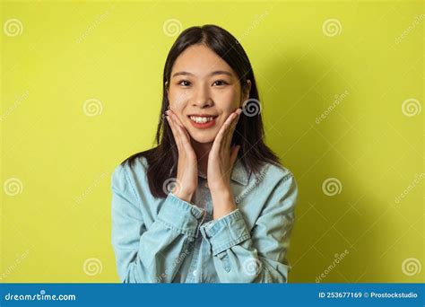 portrait of cheerful japanese woman touching face over yellow background stock image image of
