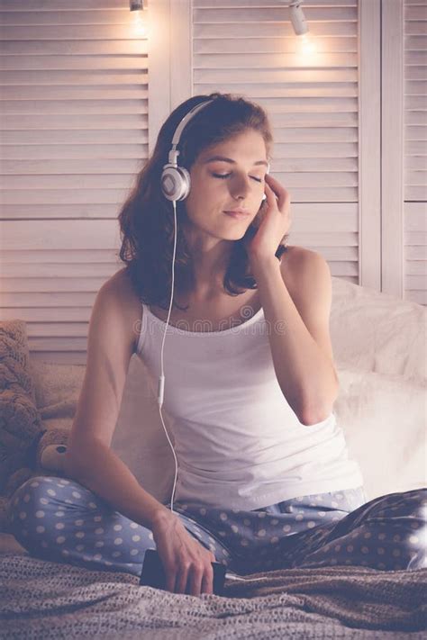 Young Woman Relaxing In Her Bed She Is Listening To Music Stock Image