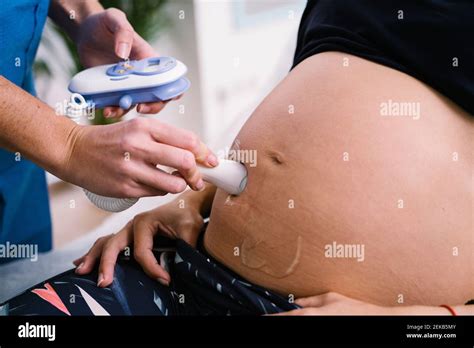 Midwife Examining Pregnant Woman Abdomen With Ultrasound Baby Heartbeat
