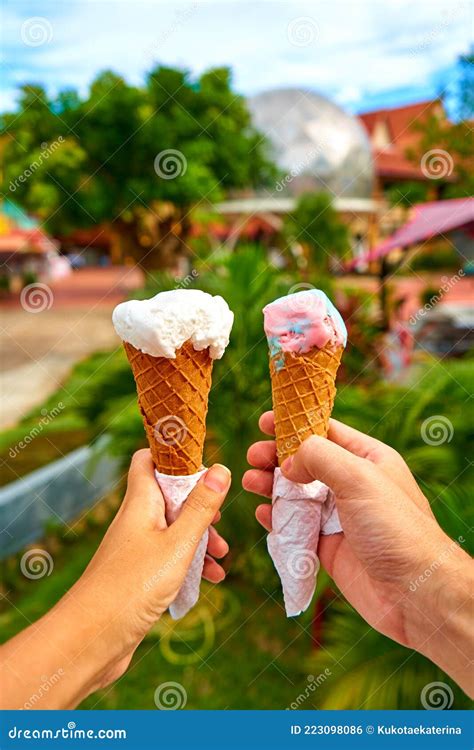 A Couple Takes Pictures Of Ice Cream Cones In Their Hands Stock Photo