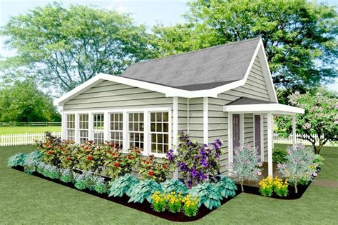 A Small House With Lots Of Flowers In The Front And Side Garden Beds