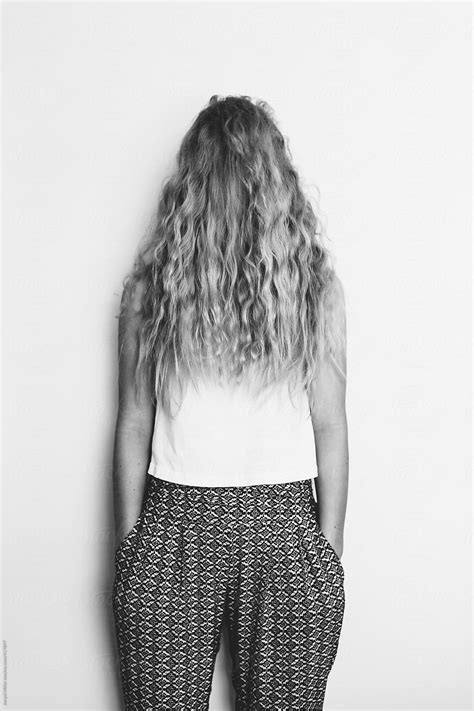Girl Hides Her Face Behind Her Long Hair By Stocksy Contributor