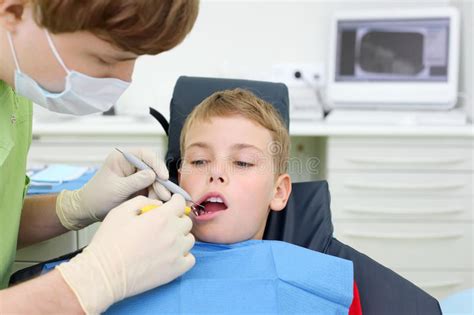Dentist Looks At Teeth Of Boy In Dental Clinic Stock Image Image Of