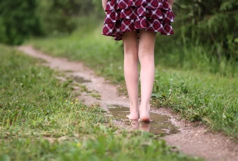 Premium Photo Barefoot Girl Walks Through A Puddles Of Water After