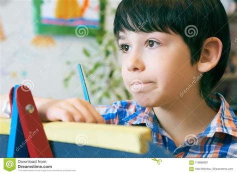 Child Standingnext To The Easel Kid Boy Learn Paint By Brush In Class