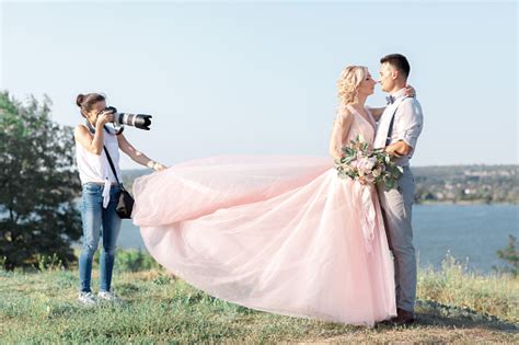 Wedding Photographer Takes Pictures Of Bride And Groom Stock Photo