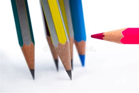 One Red Colored Wood Pencil Crayon Pointing At Five Different Colored