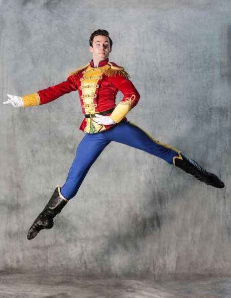 A Man In A Red And Yellow Uniform Is Jumping With His Arms Out To The Side