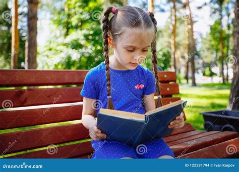 Little Girl Reading A Book In The Outdoors Stock Photo Image Of