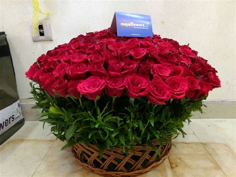 A Basket Filled With Red Roses Sitting On Top Of A Counter Next To A Phone