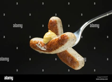 Sausages With Mustard On Fork Stock Photo Alamy
