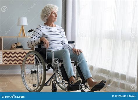 upset disabled older woman sitting in wheelchair looking out window stock image image of