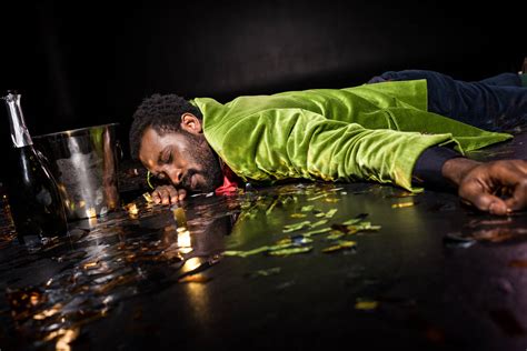 selective focus of drunk african american man lying on floor with confetti near ice bucket and