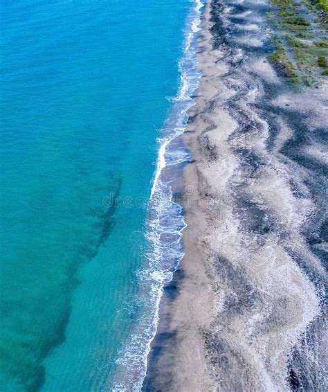 High Angle Aerial Shot Of A Beautiful Blue Water Beach Waves Hitting