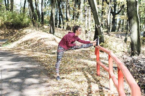 Woman Stretching In The Park Before Jogging Del Colaborador De