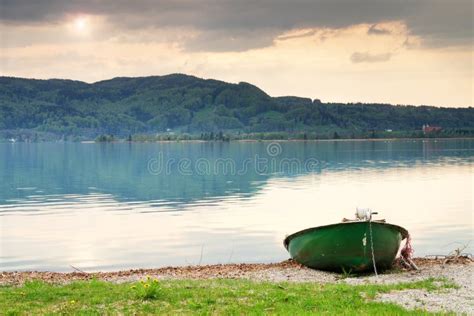 Abandoned Fishing Paddle Boat On Bank Morning Alps Lake Stock Photo