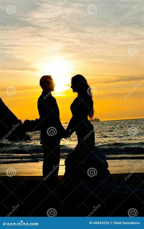 Wedding Couple Silhouette On The Beach Holding Hands Stock Photo