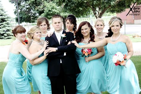 A Man In A Tuxedo Poses With His Bridesmaids