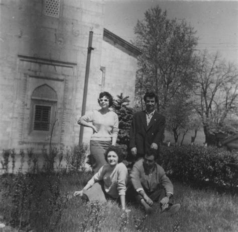 An Old Black And White Photo Of Three People In Front Of A Building