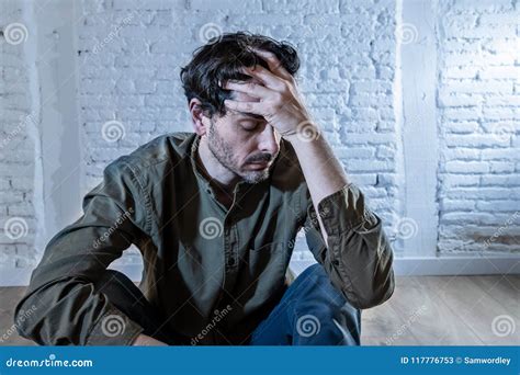 Sad Depressed Man Leaning Against A Wall In Mental Health Concept Stock