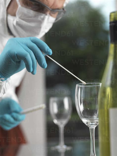 Forensic Scientist Using A DNA Swab To Take Evidence From A Glass At A