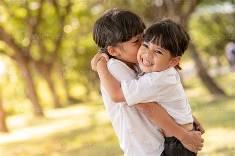 Two Asian Little Child Girls Hugging Each Other With Love In The Garden