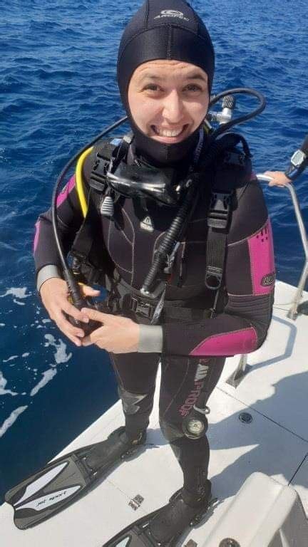 a woman in scuba gear standing on a boat