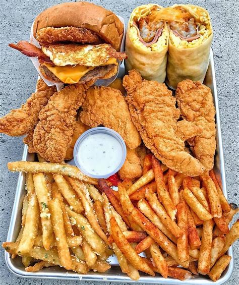 Fried Chicken French Fries And Hot Dogs On A Metal Tray With Condiments