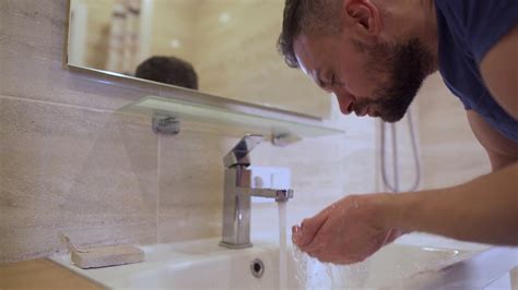 Morning Hygiene Man Washes His Face With Clean Water In The Bathroom Slow Motion Stock Video