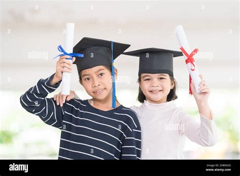 Graduation Concept With Two Happy Southeast Asian Schoolgirls With Certificates In Thailand