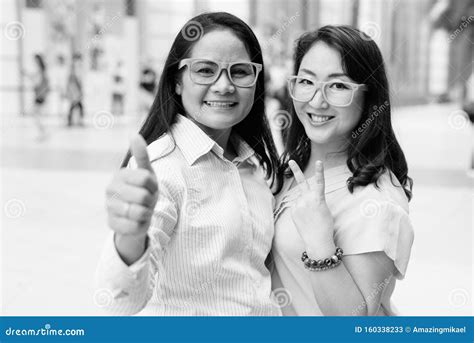 Two Asian Women Wearing Eyeglasses Outdoors In Black And White Stock