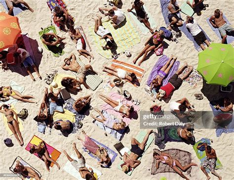 Crowd Of People Sunbathing On Beach Over Head View High Res Stock Photo