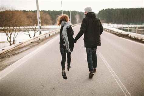 Young Couple Running On The Empty Road Holding Hands Stock Image