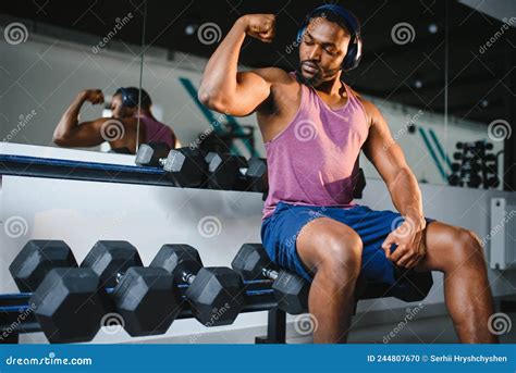 Black Athlete Flexing Muscles Demonstrating Strong Biceps In Gym Stock