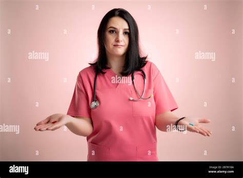 Portrait Of Beautiful Woman Doctor With Stethoscope Wearing Pink Scrubs Showing Red And Blue