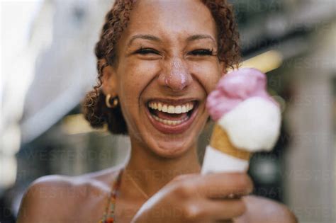 Cheerful Young Woman Having Fun With Ice Cream In Hand Stock Photo