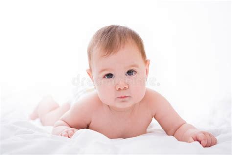 Adorable Little Baby Girl Playing With A Pacifier On White Bed Stock
