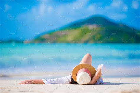 Young Woman Enjoying The Sun Sunbathing By Perfect Turquoise Ocean